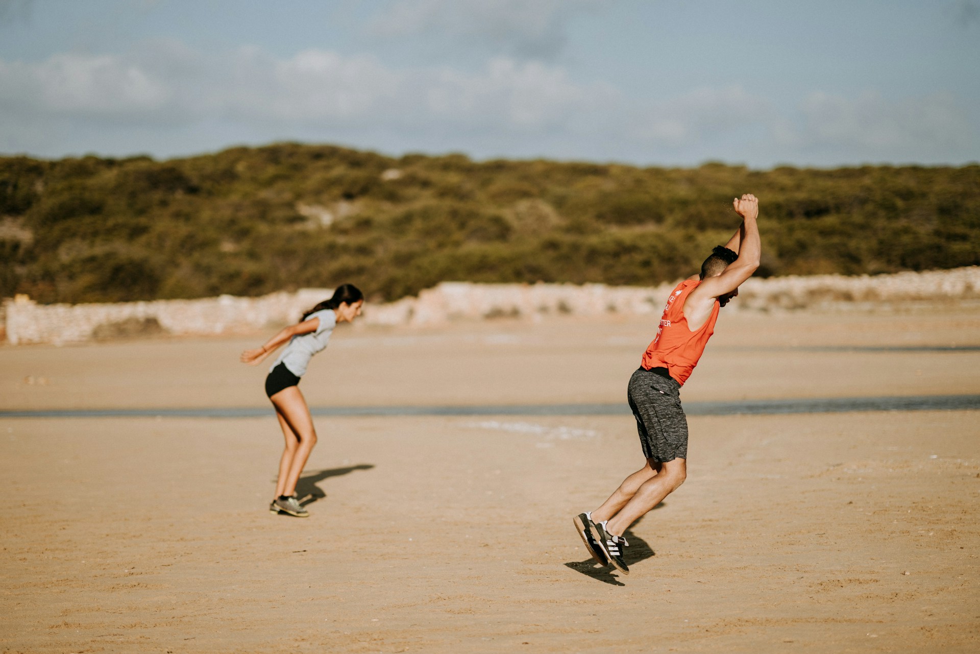 photo - two people working out on a beach 