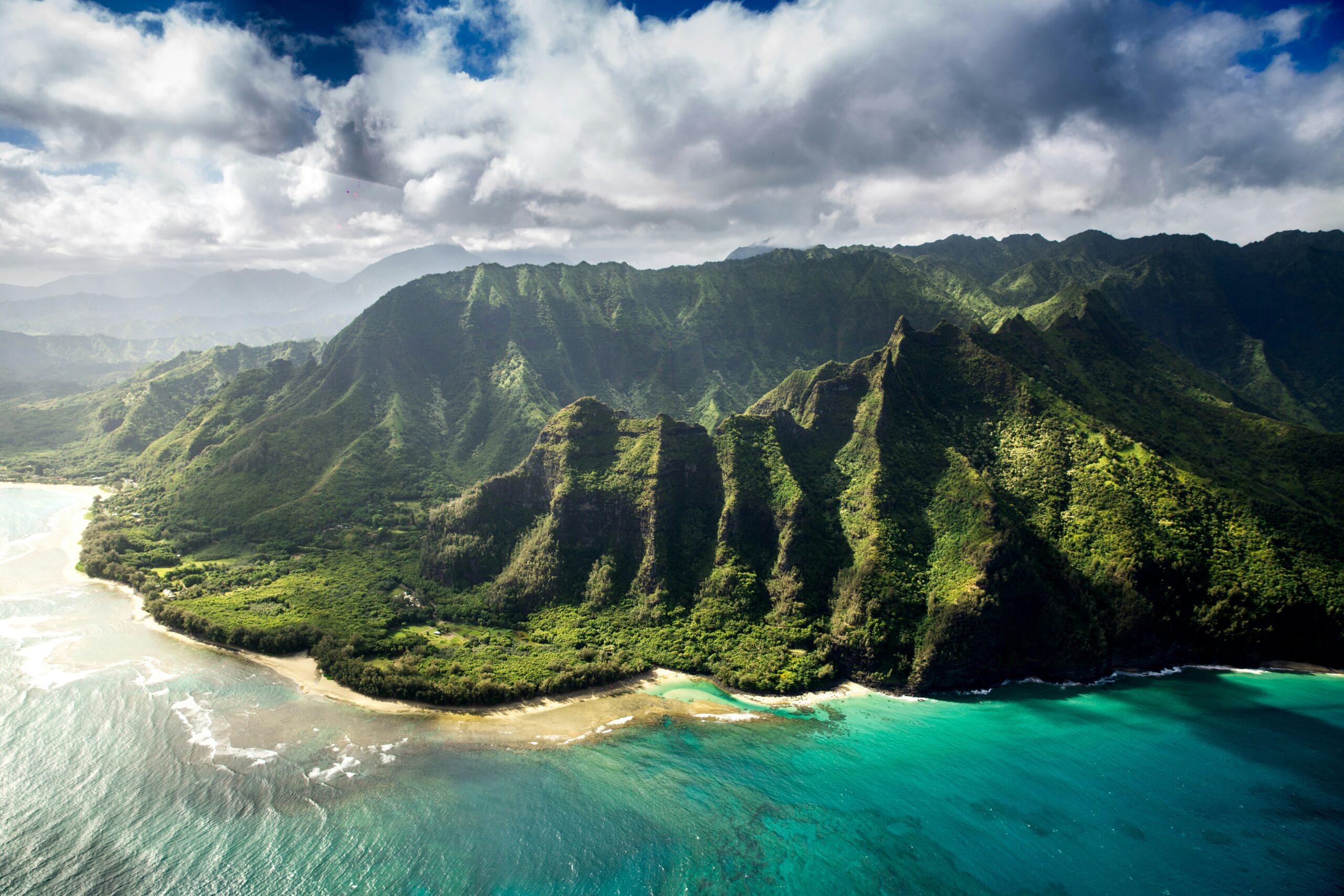 photo - beautiful hawaiian landscape with green mountains and blue ocean water where hawaiian surfers love to surf