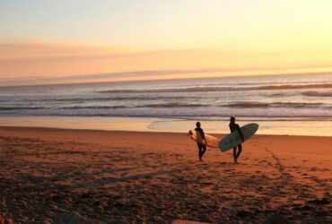 photo - two surfers walking at one of the beginner surf spots oahu on the north shore with surfboards