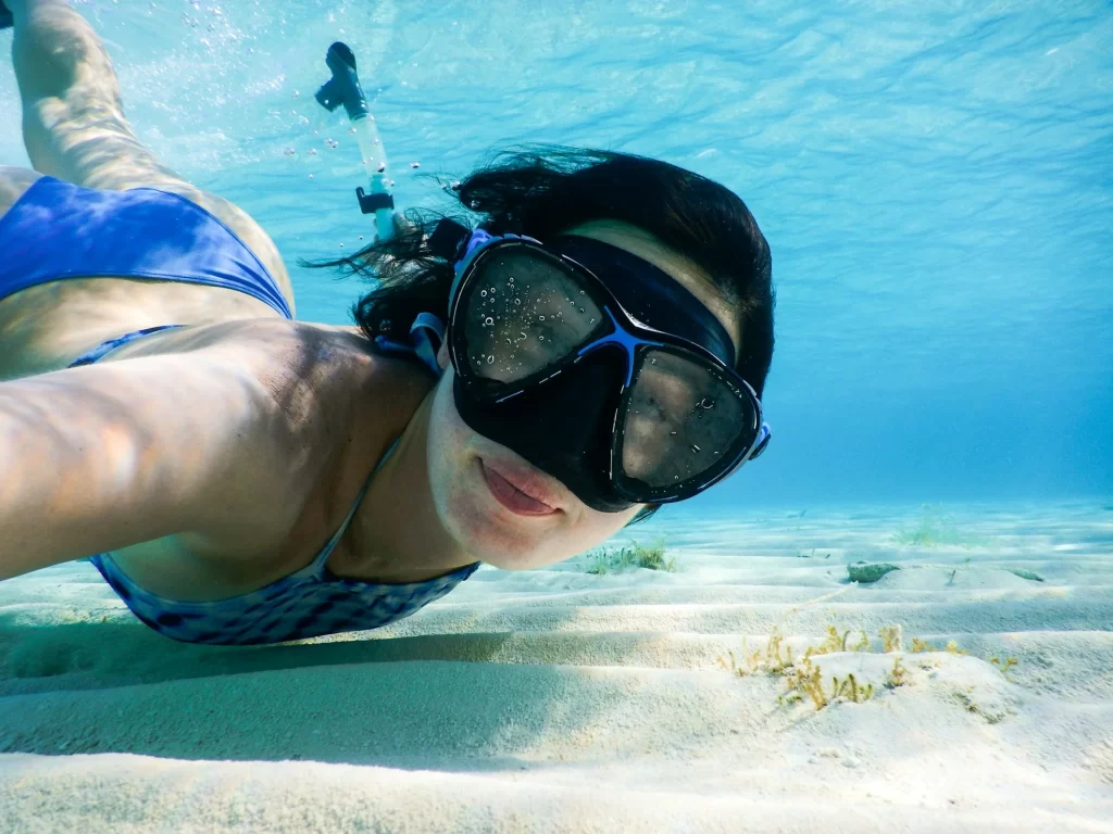 photo - a smiling woman is staring at the camera while doing waikiki snorkeling