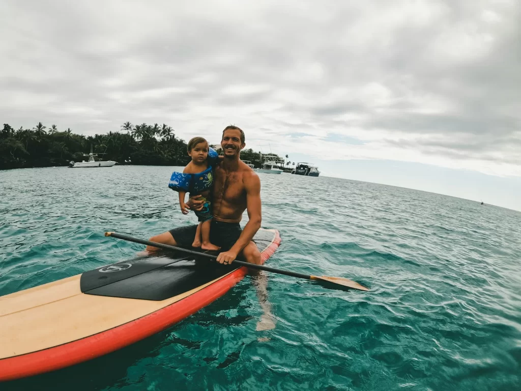 photo - a father and son doing paddle boarding honolulu