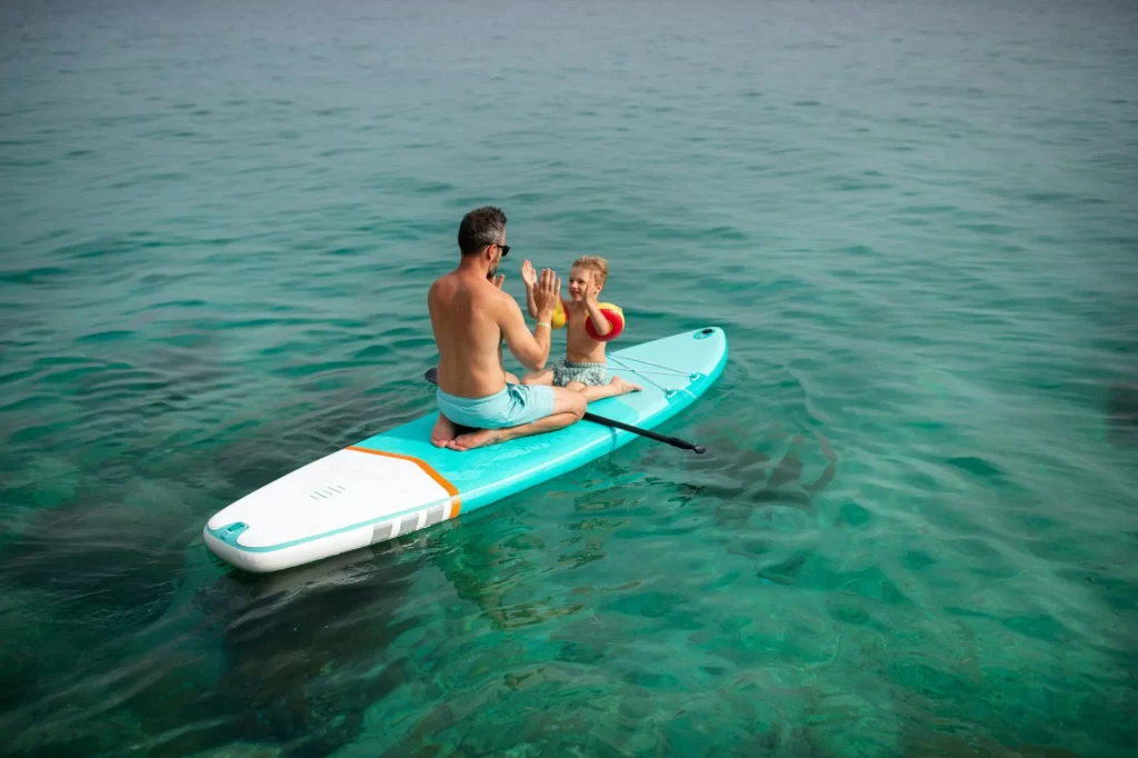 photo - a dad and child doing paddle boarding oahu