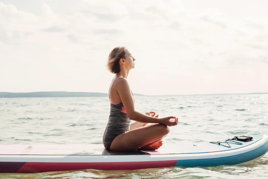 photo - a woman meditating on the water on a paddle board rental oahu