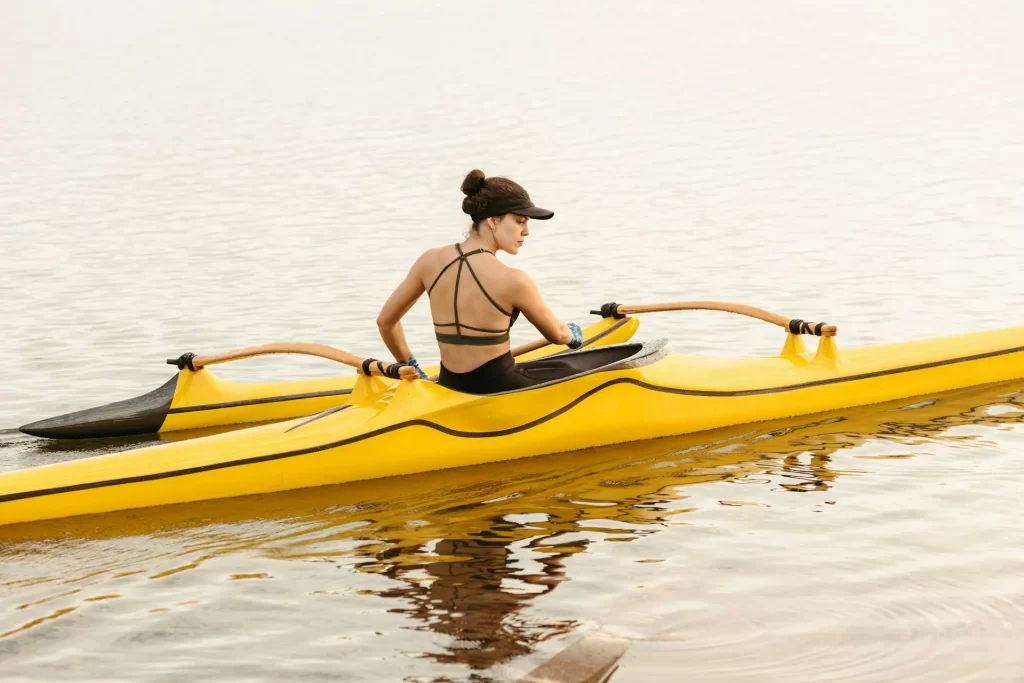 photo - a young woman in a yellow hawaiian canoe on the water