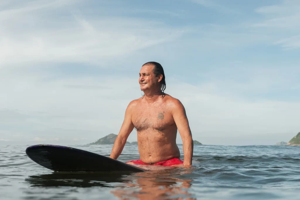 photo - happy man on the surf board enjoying benefits of surfing