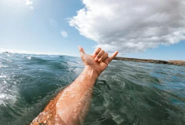 photo - a surfer's hand in the water indicative great Water Temperature Waikiki