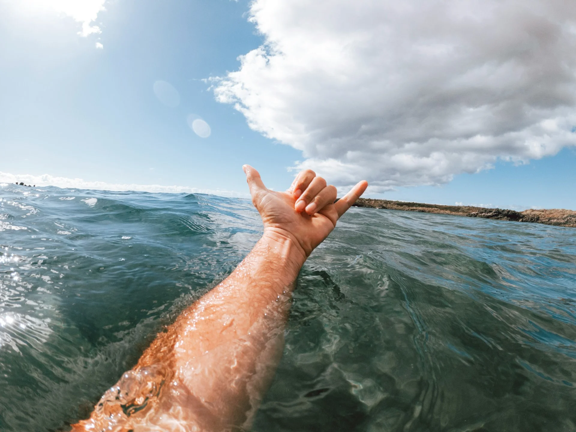 photo - a surfer's hand in the water indicative great Water Temperature Waikiki