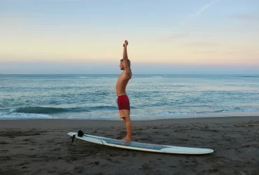 photo - a man performing surfing exercises before going into the ocean to enjoy the many benefits of surfing in Hawaii