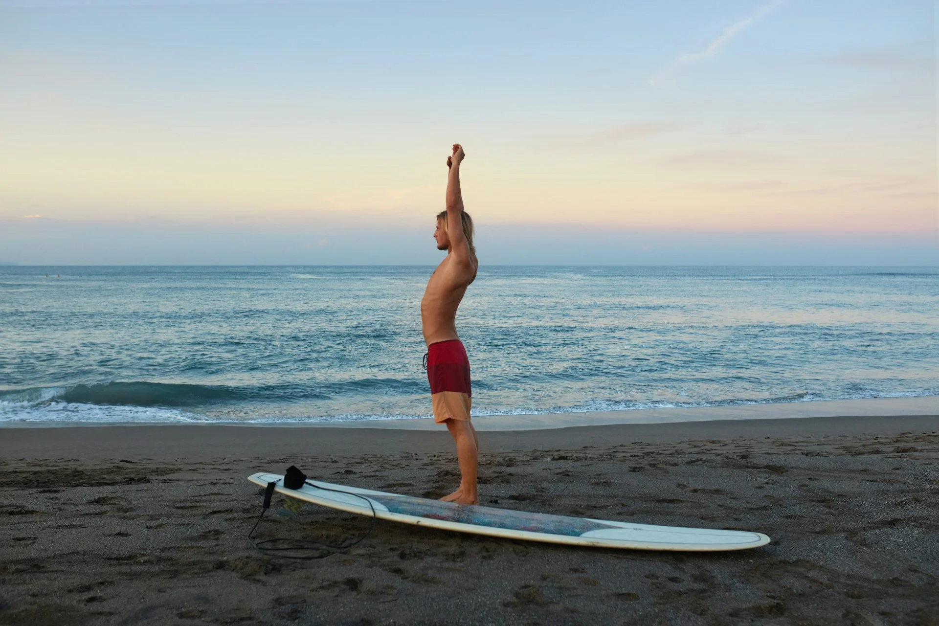 photo - a man performing surfing exercises before going into the ocean to enjoy the many benefits of surfing in Hawaii