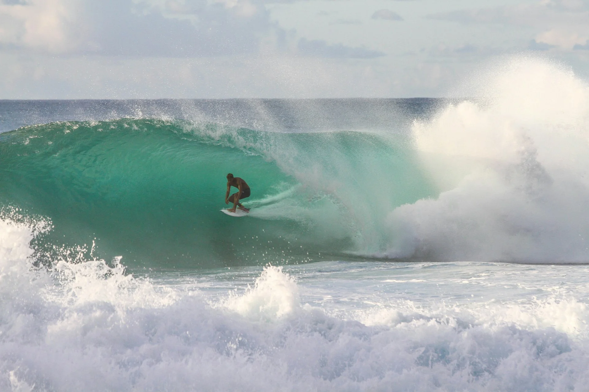 photo - a man barrel surfing in a huge wave