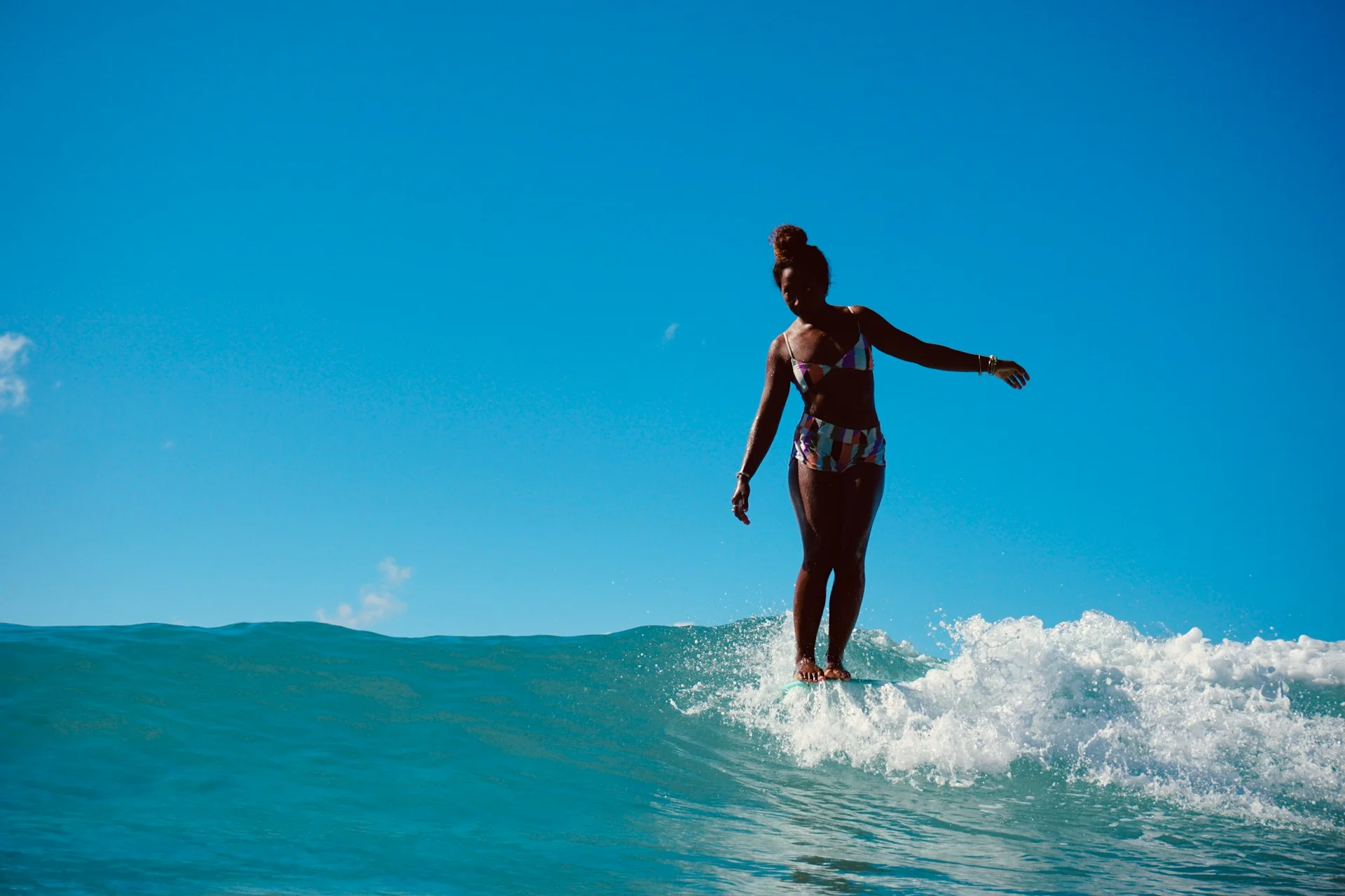 photo - a woman on a surfboard is using safe ways to surf